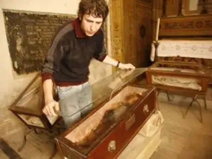 Un ingrijitor de la catacombe acopera o a doua foaie de sticla peste sicriul Rosaliei pentru o protectie suplimentara